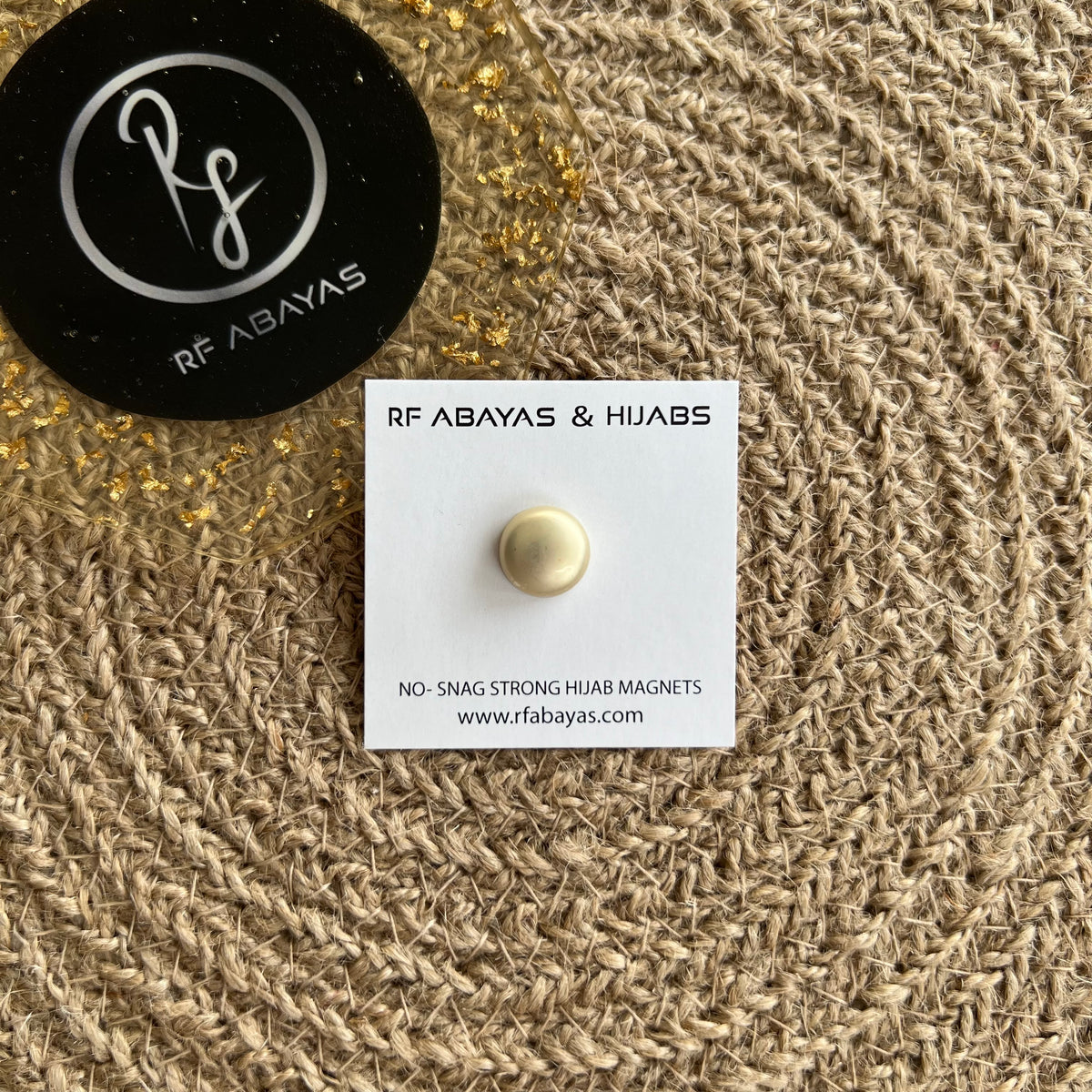Pair of round black RF Abayas hijab magnets, magnetic pins for securing hijabs, shown in matte black finish.